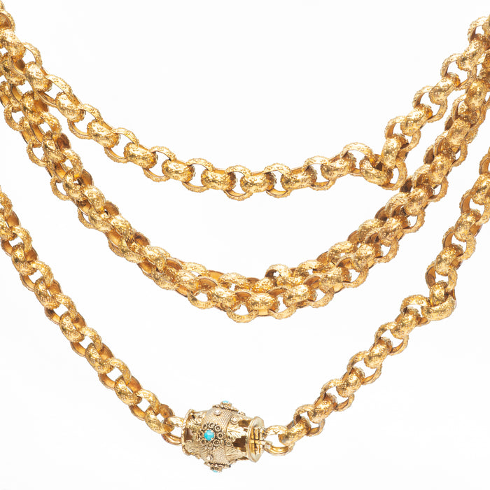 Close-up of antique textured Pinchbeck chain with turquoise cabochon barrel clasp, highlighting gold-toned links and Victorian detailing.