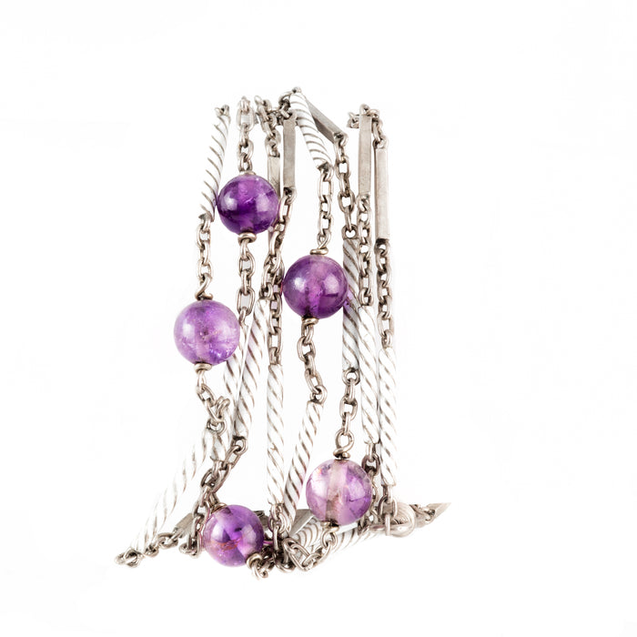 Close-up of antique Art Deco necklace showing enamel detail and polished purple amethyst beads