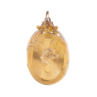 Close-up of an antique Victorian 18ct gold locket engraved with radiating lines and foliate details, c.1880.