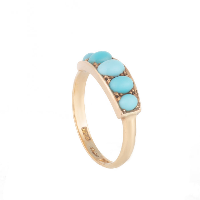 Close-up of vintage turquoise cabochons with smooth domed finish in gold setting